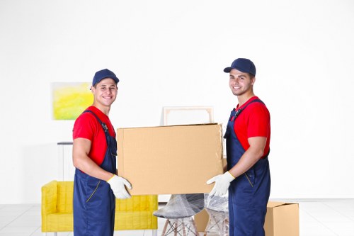 Movers carrying household items from a flat with stairs in Wandsworth